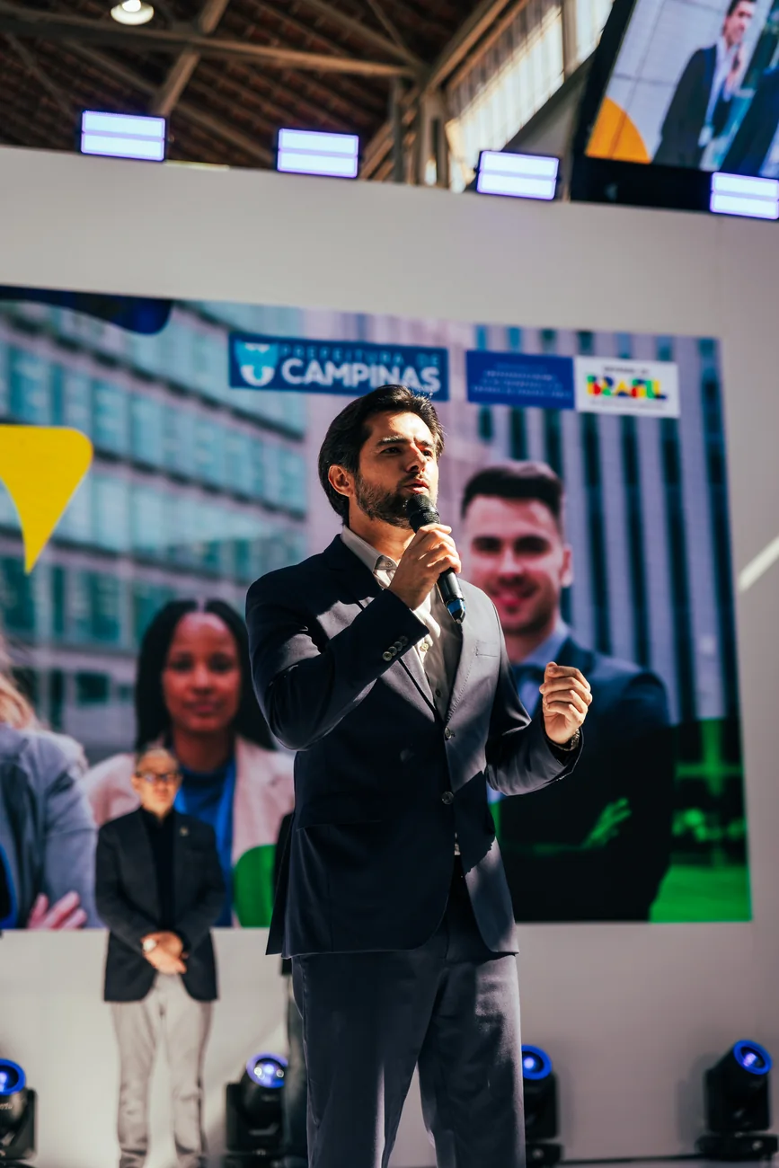 Executivo apresentando resultados do ano no palco de evento corporativo em Campinas