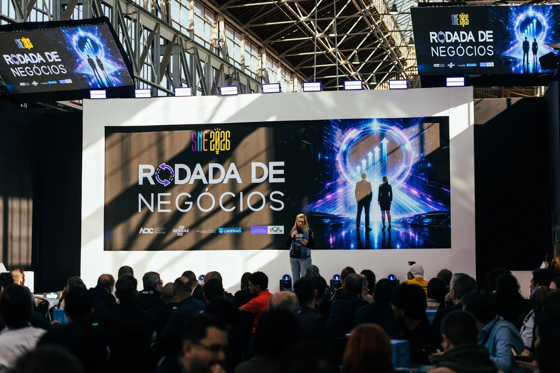 Palco iluminado com telão durante premiação em evento corporativo