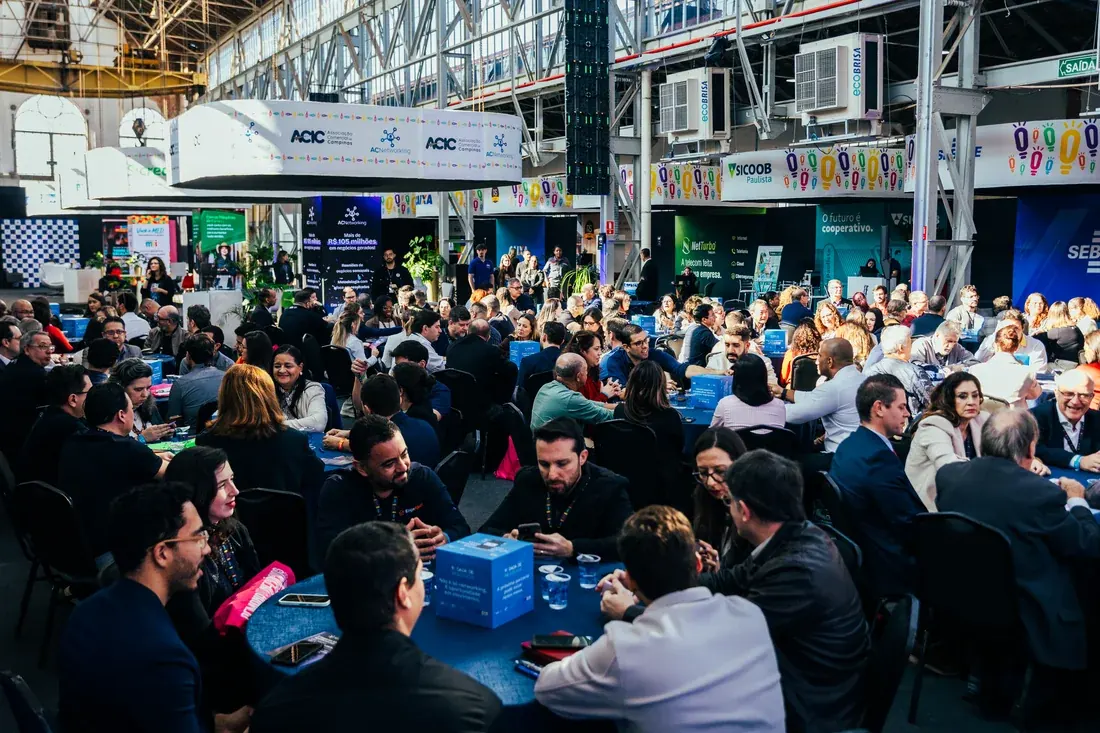 Salão cheio com colaboradores em mesas durante evento de empresa em Campinas