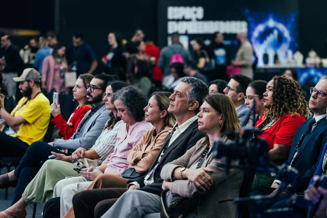 Plateia atenta em palestra durante feira de negócios, em cobertura fotográfica de PH Marx