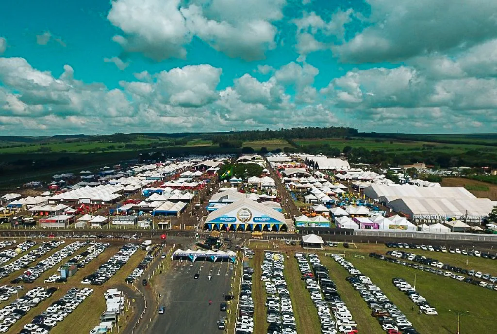 Vista aérea de feira a céu aberto com tendas e estacionamento em Ribeirão Preto