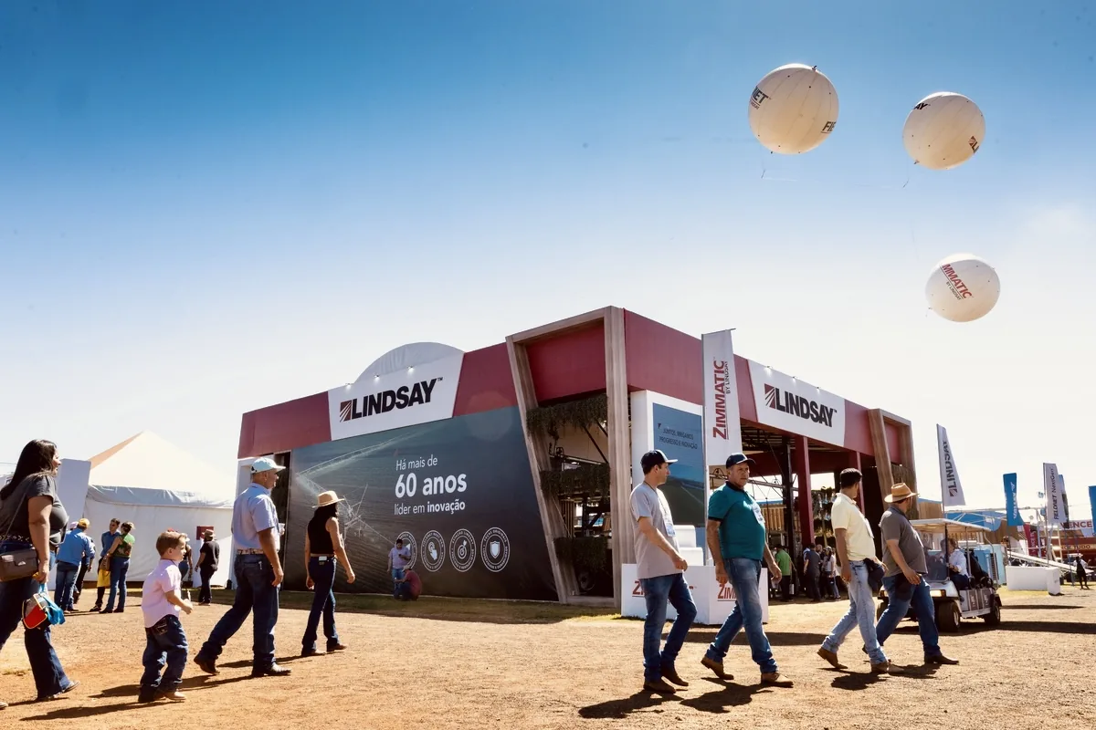 Estande na Agrishow em Ribeirão Preto com visitantes e máquinas agrícolas, cobertura fotográfica de PH Marx