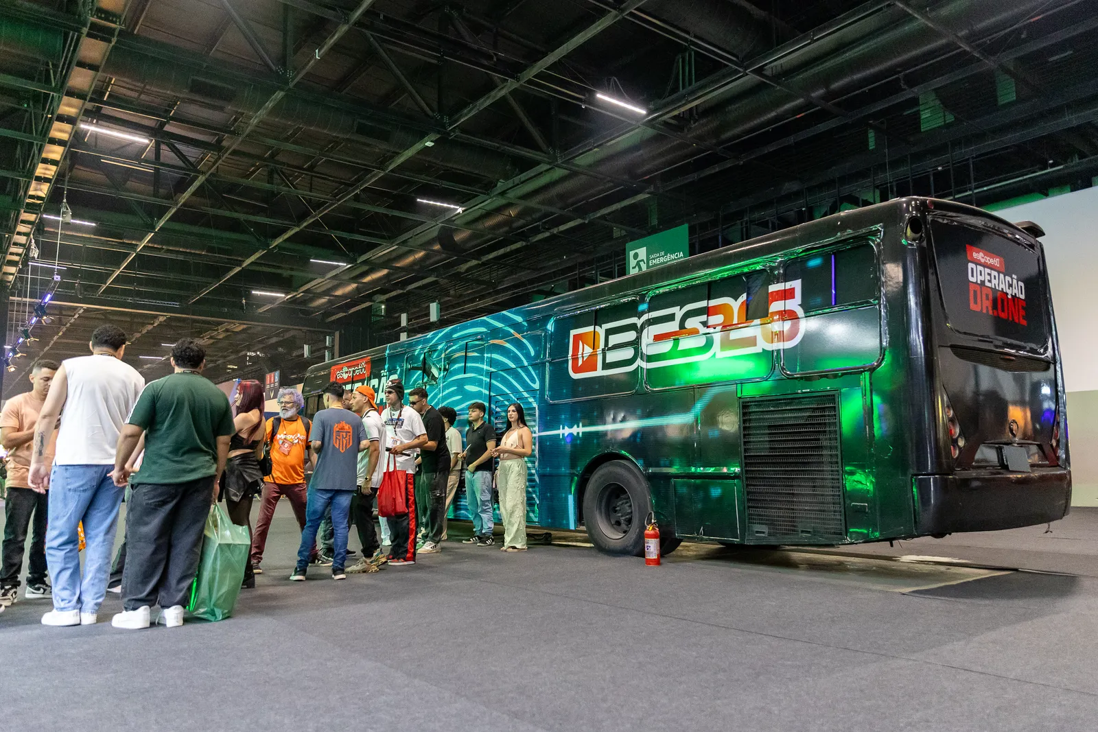 Ônibus envelopado em ativação de marca no Distrito Anhembi, com público em volta, em cobertura fotográfica de PH Marx