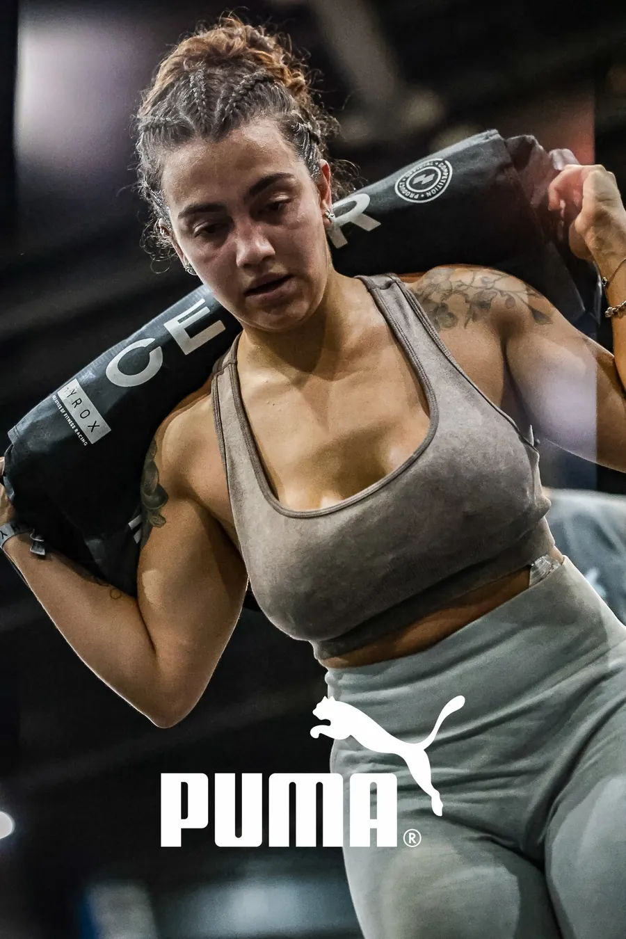 Atleta de HYROX carregando sandbag, foto com a marca Puma aplicada