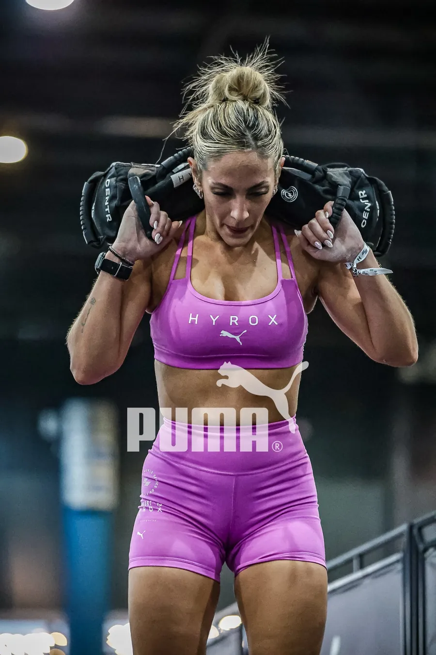 Atleta de HYROX na estação de sandbag lunges, foto com a marca Puma aplicada