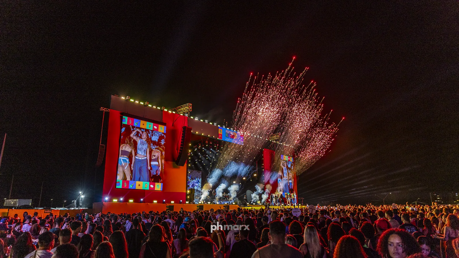 Show ao vivo com luz cênica e público em festival fotografado por PH Marx