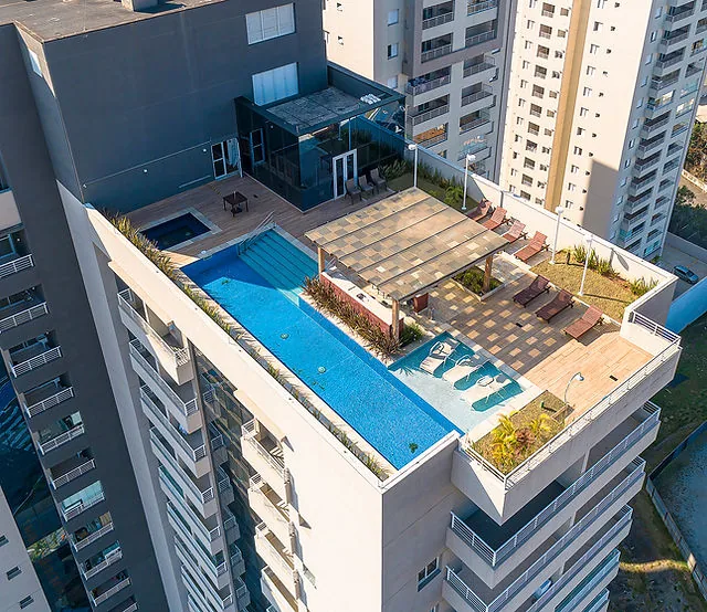 Vista aérea de cobertura com piscina no topo de condomínio residencial vertical