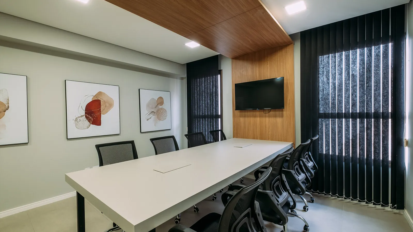 Sala de reunião ampla com mesa longa e painel de madeira em imóvel comercial