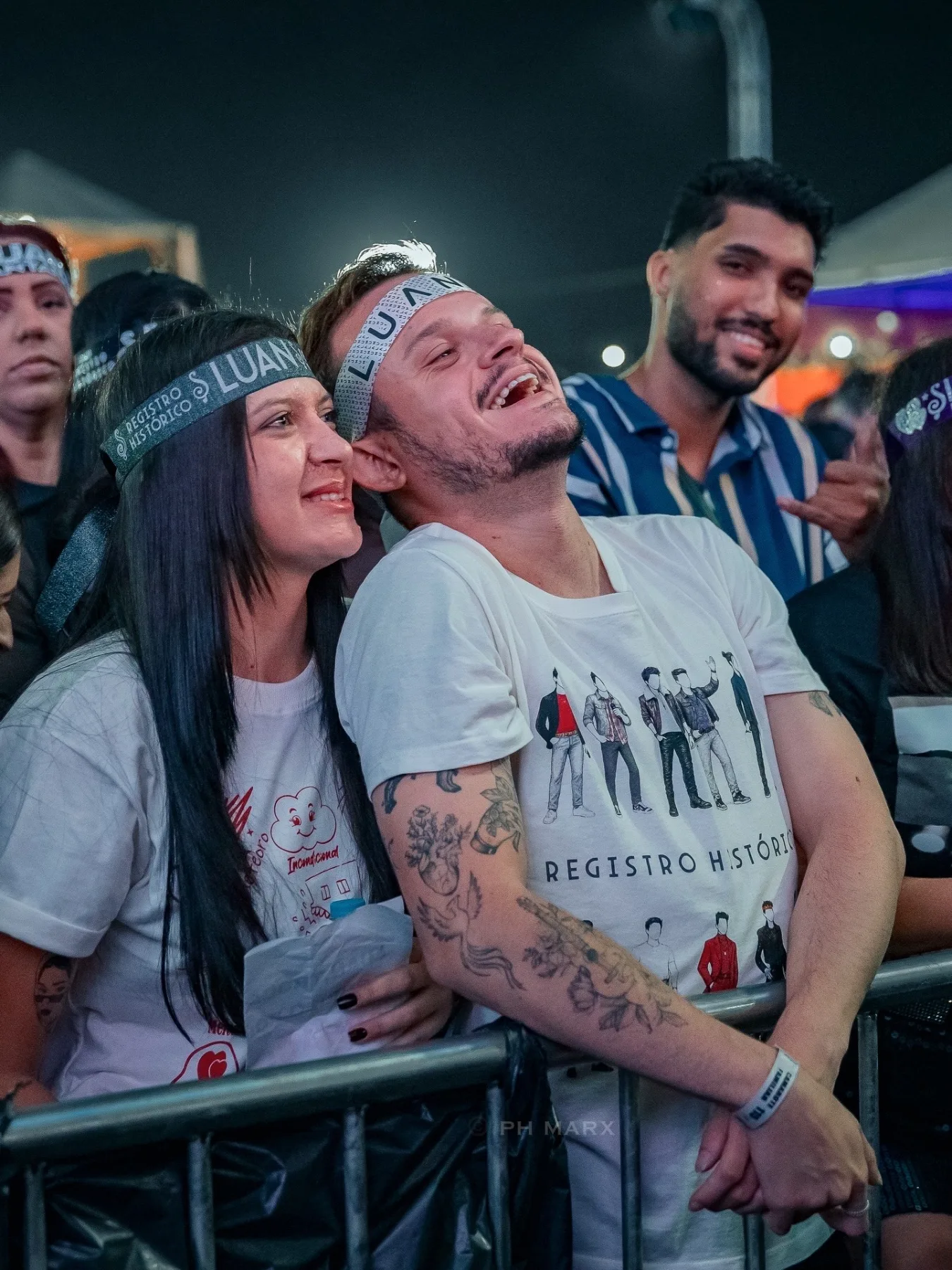Fãs emocionados na grade cantando durante show ao vivo, fotografia de público por PH Marx