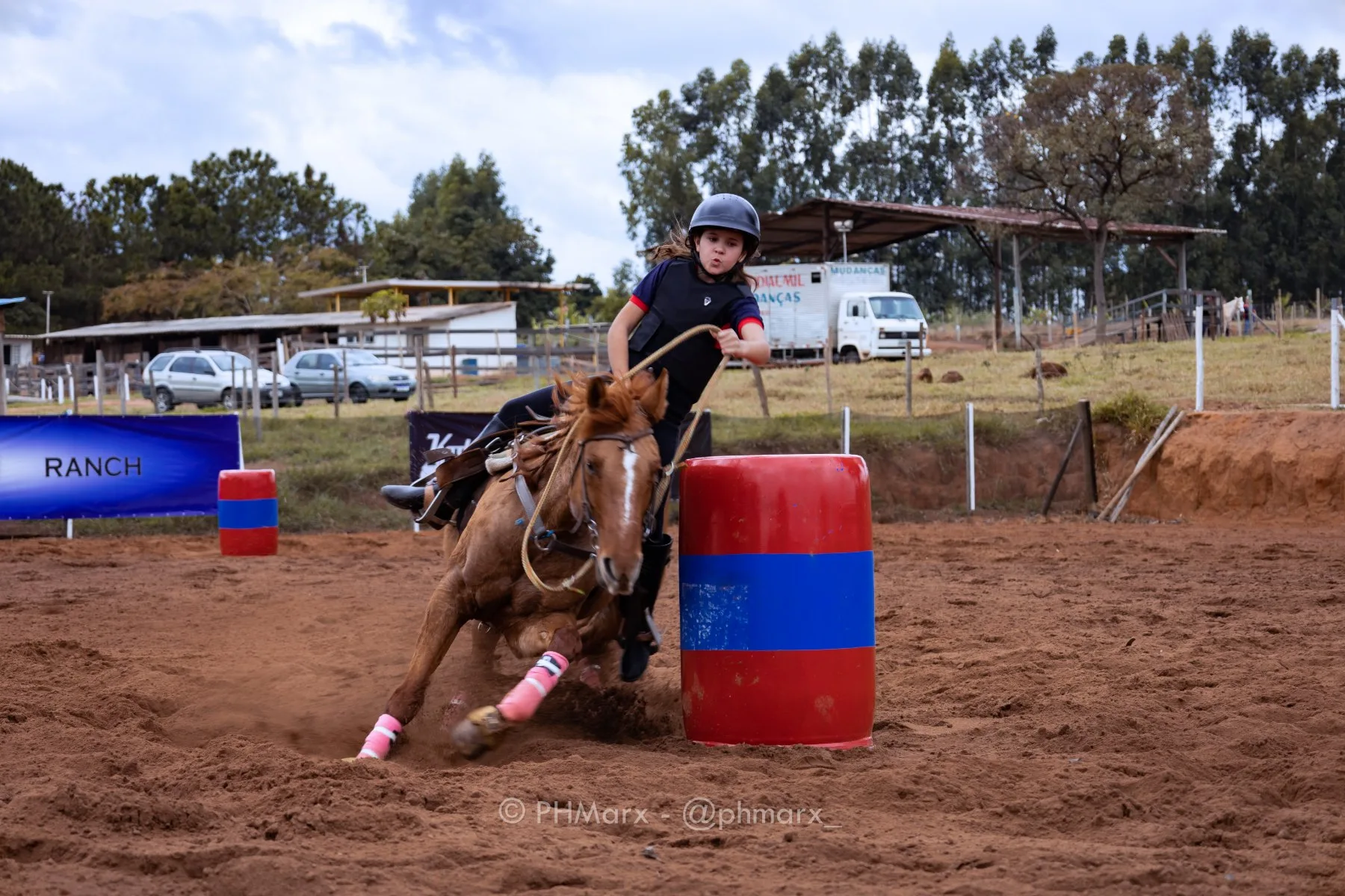 Prova de Três Tambores em arena, cavalo e cavaleira no giro do tambor, por PH Marx